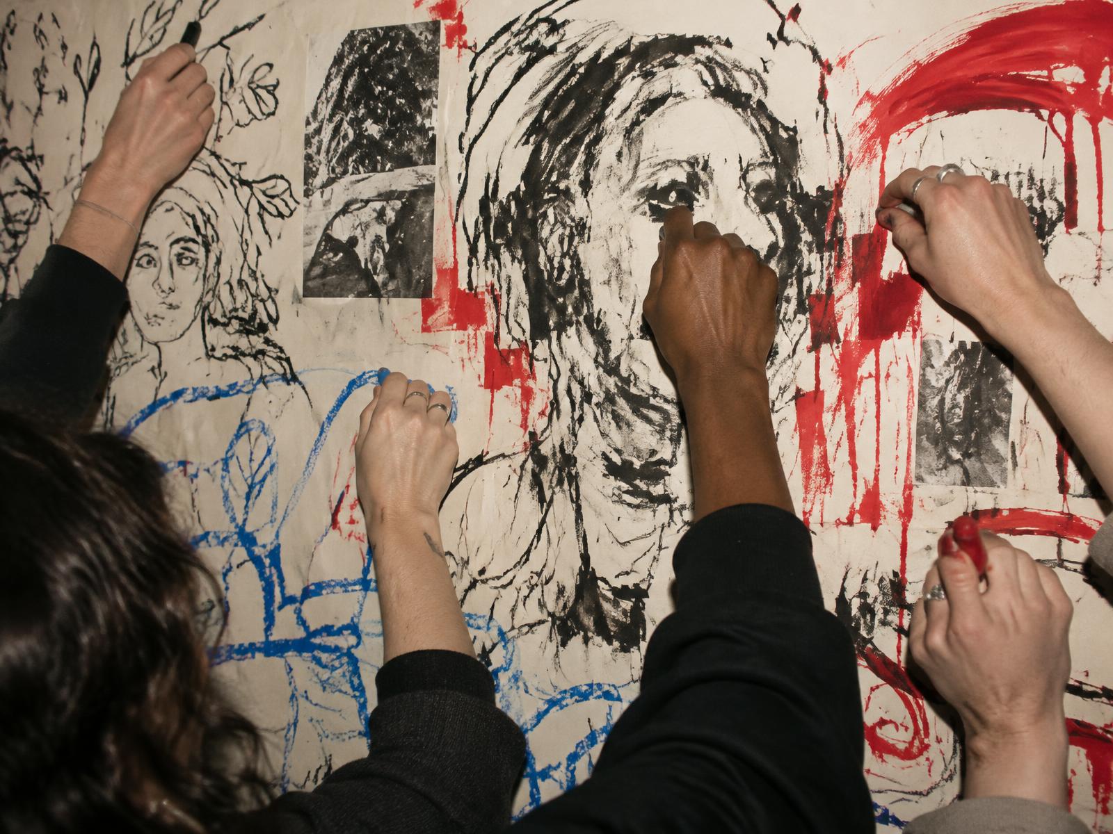 Hands drawing on the evolving living wall